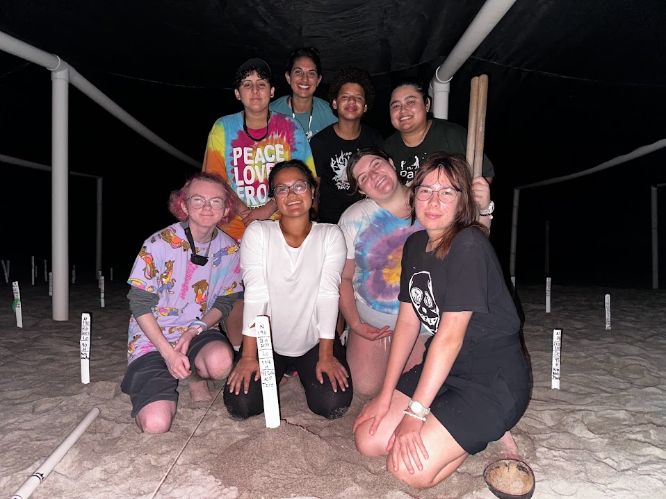 Group of students pose by a turtle nest