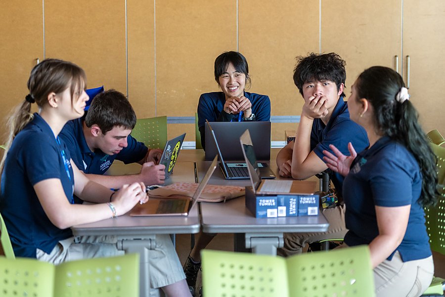 Group of teen volunteers of teens at table working