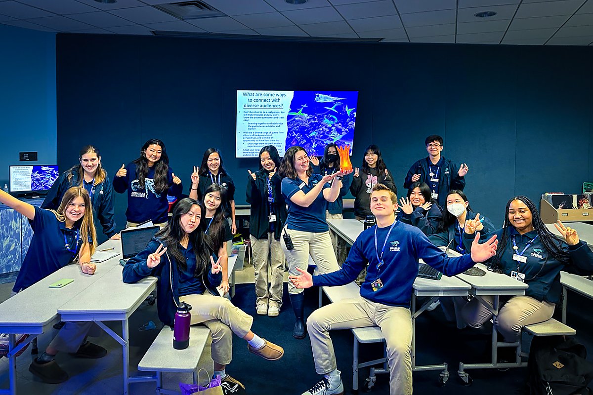 Classroom with teenagers in Aquarium uniform smiling in a group.