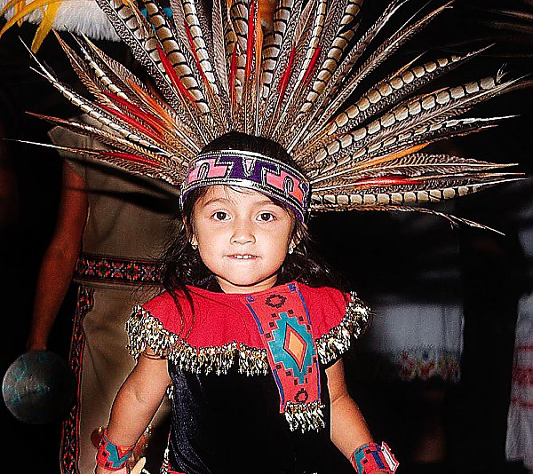 Child wearing traditional Aztec headdress and outfit