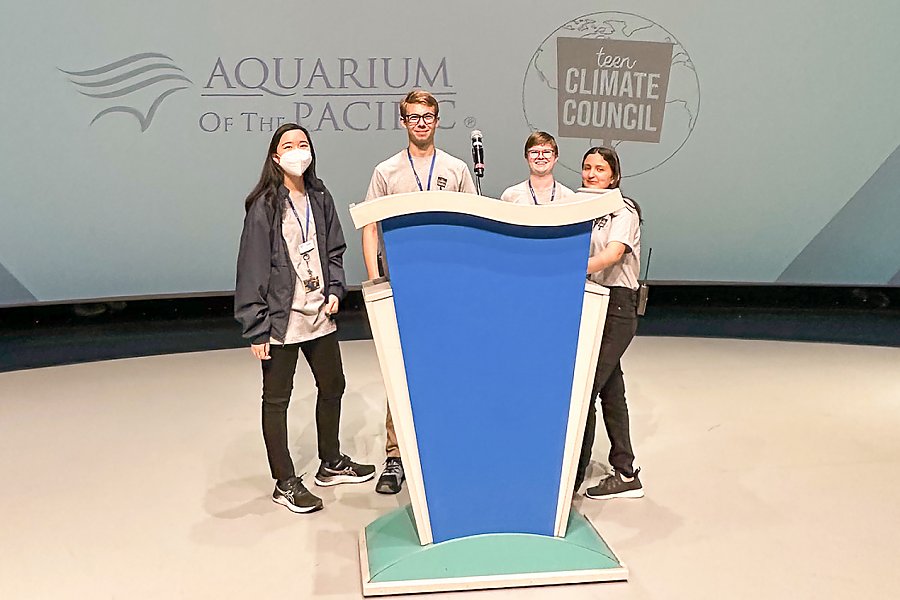 teens behind a podium smiling