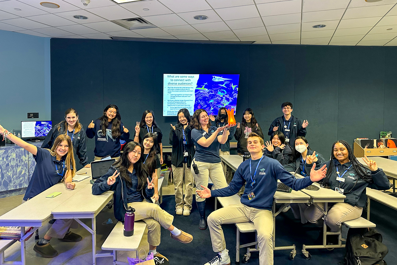 Classroom with teenagers in aquarium uniform smiling in a group